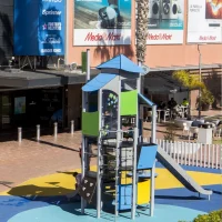 Parque infantil con tobogán y juegos frente al centro comercial Barnasud de Gavà