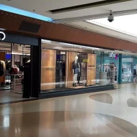 Zona de tiendas de moda con escaparates de Mango y Druni en Barnasud Gavà
