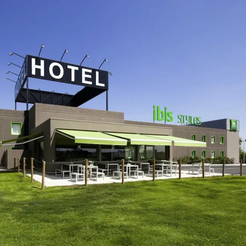 Exterior Hotel Ibis Styles Torrefarrera con terraza de restaurante junto a pradera de césped